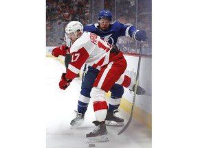 Detroit Red Wings defenseman Filip Hronek (17) checks Tampa Bay Lightning center Tyler Johnson (9) in the first period of an NHL hockey game, Thursday, March 14, 2019, in Detroit.