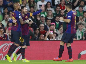 Barcelona's Messi, second left, celebrates after scoring with teammate Aleix Vidal, left, and Suarez during La Liga soccer match between Betis and Barcelona at the Benito Villamarin stadium in Seville, Spain, Sunday, March 17, 2019.