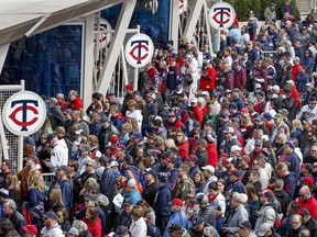 Fans enter the ballpark for the baseball game between the Cleveland Indians and the Minnesota Twins Thursday, March 28, 2019, in Minneapolis.