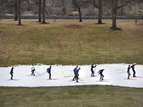 FILE - In this Dec. 11, 2016 file photo, St. Cloud Cathedral/Sartell Nordic ski team members practice on a track of man-made snow at Riverside Park in St. Cloud, Minn., where lack of snow in the area made it difficult for teams to practice. Since 1970, Minnesota's winters have been warming at a rate of more than 1 degree a decade. State residents notice the change, and say winter isn't as cold as it used to be and the snow is less predictable.