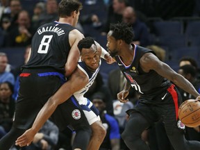 Minnesota Timberwolves' Josh Okogie, center, tries to get past Los Angeles Clippers' Danilo Gallinari, left, as Patrick Beverley in the first half of an NBA basketball game Tuesday, March 26, 2019, in Minneapolis.