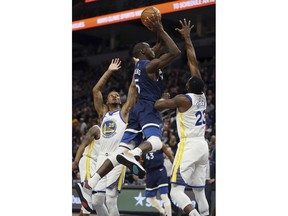 Minnesota Timberwolves' Gorgui Dieng shoots over Golden State Warriors' Draymond Green during the first half of an NBA basketball game Friday, March 29, 2019, in Minneapolis.