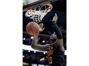 Oklahoma State's Isaac Likekele watches the ball after his dunk during the first half of the team's NCAA college basketball game against TCU in the Big 12 men's tournament Wednesday, March 13, 2019, in Kansas City, Mo.