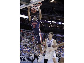 Auburn's Horace Spencer (0) dunks over Kentucky's Reid Travis (22) during the first half of the Midwest Regional final game in the NCAA men's college basketball tournament Sunday, March 31, 2019, in Kansas City, Mo.