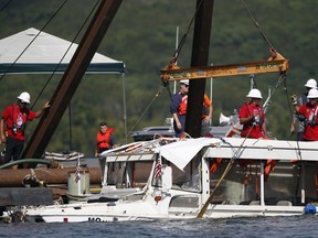 FILE- In this July 23, 2018, file photo the duck boat that sank on July 19 in Table Rock Lake in Branson, Mo., is raised. The company that owns the boat that sank last summer, killing 17 people, announced Thursday, March 21, 2019,  that it won't operate the vessels this year because of the ongoing investigation and will instead open a replacement attraction in the tourist town of Branson.