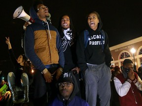 FILE - In this Nov. 24, 2014 file photo, Ferguson activist Daren Seals, top center, awaits the decision by a grand jury on whether to indict Darren Wilson in the death of Michael Brown in front of the police station in Ferguson , Mo. Six young men with connections to the Ferguson protests, including Seals, have died, drawing attention on social media and speculation in the activist community that something sinister is at play. Police say there is no evidence the deaths have anything to do with the protests and note that only two were homicides. But activists and observers remain puzzled and wonder if they'll ever get answers. The 29-year-old's bullet-riddled body was found inside a burning car in September 2016.