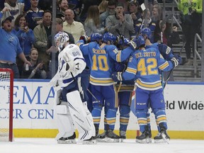 St. Louis Blues' Brayden Schenn (10) and Michael Del Zotto (42) celebrate with teammates after a goal by Vladimir Tarasenko (91) as Tampa Bay Lightning goaltender Andrei Vasilevskiy (88) skates past in the first period of an NHL hockey game, Saturday, March 23, 2019, in St. Louis.