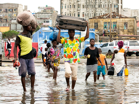People carry their personal effects after Tropical Cyclone Idai, in Beira, Mozambique, March 15, 2019.