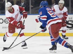 Detroit Red Wings center Luke Glendening shoots the puck around New York Rangers defenseman John Gilmour (58) during the first period of an NHL hockey game, Tuesday, March 19, 2019, at Madison Square Garden in New York.