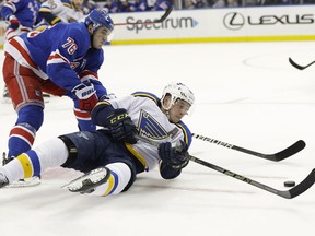 New York Rangers' Brady Skjei, left, fights for control of the puck with St. Louis Blues' Vladimir Tarasenko during the first period of an NHL hockey game Friday, March 29, 2019, in New York.