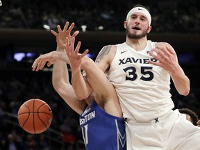 Xavier's Zach Hankins (35) fights for control of the ball with Creighton's Samson Froling during the first half of an NCAA college basketball game in the Big East men's tournament Thursday, March 14, 2019, in New York.