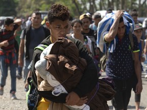 Central American migrants, part of the caravan hoping to reach the U.S. border, move on a road in Tapachula, Chiapas State, Mexico, Thursday, March 28, 2019. A caravan of about 2,500 Central Americans and Cubans is currently making its way through Mexico's southern state of Chiapas.