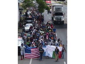 Central American migrants, part of the caravan hoping to reach the U.S. border, move on a road in Tapachula, Chiapas State, Mexico, Thursday, March 28, 2019. A caravan of about 2,500 Central Americans and Cubans is currently making its way through Mexico's southern state of Chiapas.