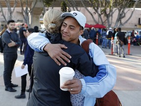 A man who only gave his first name as Ariel, of Honduras, hugs an attorney before crossing into the United States to begin his asylum case after being returned to Mexico, Tuesday, March 19, 2019, in Tijuana, Mexico. A group of about five men were on their way to report for their first hearing under a new policy to make asylum seekers wait in Mexico while their case winds through U.S. immigration court.