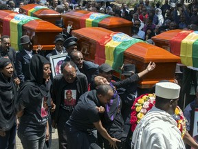 Relatives grieve next to empty caskets draped with the national flag at a mass funeral at the Holy Trinity Cathedral in Addis Ababa.