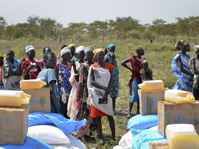 FILE - In this Saturday, Dec. 9, 2017 file photo, people wait in line for food rations at a World Food Program distribution in Jiech, Ayod County, South Sudan. South Sudan's committee overseeing the fragile transition from civil war has approved almost $185 million in spending on vehicles, food and home renovations while the country's peace deal suffers from an alleged lack of funds, according to internal documents seen by The Associated Press.