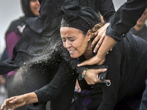 An Ethiopian relative of a crash victim throws dirt in her own face after realising that there is nothing physical left of her loved one, as she mourns at the scene where the Ethiopian Airlines Boeing 737 Max 8 crashed shortly after takeoff on Sunday killing all 157 on board, near Bishoftu, south-east of Addis Ababa, in Ethiopia Thursday, March 14, 2019. About 200 family members of people who died on the crashed jet stormed out of a briefing with Ethiopian Airlines officials in Addis Ababa on Thursday, complaining that the airline has not given them adequate information.