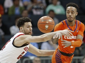 Clemson's Marcquise Reed (2) passes the ball past North Carolina State's Devon Daniels (24) during the first half of an NCAA college basketball game in the Atlantic Coast Conference tournament in Charlotte, N.C., Wednesday, March 13, 2019.