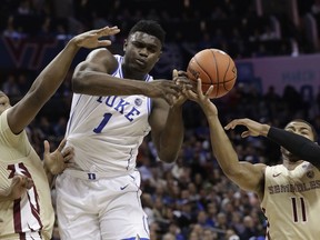Duke's Zion Williamson, center, loses the ball as he is trapped by Florida State's David Nichols, right, and Raiquan Gray, left, during the first half of the NCAA college basketball championship game of the Atlantic Coast Conference tournament in Charlotte, N.C., Saturday, March 16, 2019.
