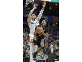 Wake Forest's Brandon Childress (0) drives past Miami's Anthony Mack (13) during the first half of an NCAA college basketball game in the Atlantic Coast Conference tournament in Charlotte, N.C., Tuesday, March 12, 2019.