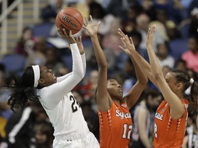 Notre Dame's Arike Ogunbowale (24) shoots against Syracuse's Kiara Lewis (12) and Miranda Drummond (32) during the first half of an NCAA college basketball game in the Atlantic Coast Conference women's tournament in Greensboro, N.C., Saturday, March 9, 2019.