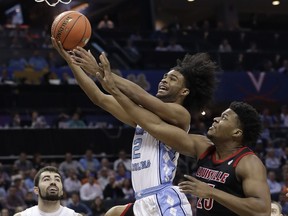 North Carolina's Coby White (2) drives past Louisville's Steven Enoch (23) during the first half of an NCAA college basketball game in the Atlantic Coast Conference tournament in Charlotte, N.C., Thursday, March 14, 2019.