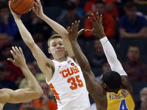 Syracuse's Buddy Boeheim (35) looks to pass the ball as Pittsburgh's Jared Wilson-Frame (4) defends during the first half of an NCAA college basketball game in the Atlantic Coast Conference tournament in Charlotte, N.C., Wednesday, March 13, 2019.