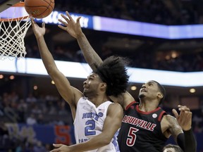 North Carolina's Coby White (2) drives past Louisville's Malik Williams (5) during the second half of an NCAA college basketball game in the Atlantic Coast Conference tournament in Charlotte, N.C., Thursday, March 14, 2019.