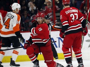 Carolina Hurricanes' Dougie Hamilton (19) celebrates his goal with Andrei Svechnikov (37) of Russia while Philadelphia Flyers' Sean Couturier (14) skates away during the first period of an NHL hockey game in Raleigh, N.C., Saturday, March 30, 2019.