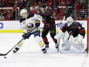 Buffalo Sabres' Sam Reinhart (23) tries to get a shot against Carolina Hurricanes goalie Curtis McElhinney (35) and Hurricanes' Andrei Svechnikov (37), of Russia, during the first period of an NHL hockey game in Raleigh, N.C., Saturday, March 16, 2019.