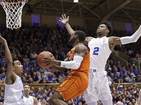 Duke's Tre Jones, left, and Cam Reddish (2) defend against Miami's Zach Johnson during the first half of an NCAA college basketball game in Durham, N.C., Saturday, March 2, 2019.