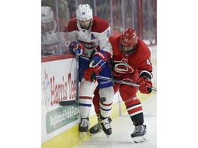 Montreal Canadiens' Paul Byron (41) and Carolina Hurricanes' Calvin de Haan (44) chase the puck during the first period of an NHL hockey game in Raleigh, N.C., Sunday, March 24, 2019.