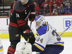 Carolina Hurricanes' Justin Williams (14) tries to score while St. Louis Blues goalie Jake Allen (34) defends during the second period of an NHL hockey game in Raleigh, N.C., Friday, March 1, 2019.