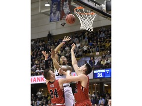 Wofford forward Cameron Jackson (33) shoots for the basket between Virginia Military forward Will Miller (24) and forward Tyler Creammer (25) in the first half of an NCAA college basketball game in the Southern Conference tournament championship, Saturday, March 9, 2018, in Asheville, N.C.