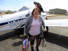 Connie Hamilton gets off a volunteer aircraft that brought her back home to Fremont, Neb., Monday, March 18, 2019, after she was stranded in Omaha due to floods. Walled off by massive flooding, Fremont is getting a big lift from private pilots who are offering free flights to shuttle stranded residents to and from their hometown. Authorities say flooding from the Platte River and other waterways is so bad that just one highway lane into Fremont remains uncovered, and access to that road is severely restricted. Airport officials estimate that more than 500 people have caught flights on small aircraft flown by volunteers.