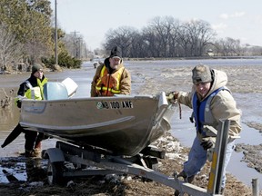 RETRANSMISSION TO CORRECT SURNAME - Tom Wilke, center, his son Chad, right, and Nick Kenny, load a boat out of the swollen waters of the North Fork of the Elkhorn River after checking on the Witke's flooded property, in Norfolk, Neb., Friday, March 15, 2019. Heavy rain falling atop deeply frozen ground has prompted evacuations along swollen rivers in Wisconsin, Nebraska and other Midwestern states. Thousands of people have been urged to evacuate along eastern Nebraska rivers as a massive late-winter storm has pushed streams and rivers out of their banks throughout the Midwest.