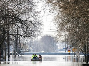 People on a boat float down floodwaters that cover Washington Street Wednesday, March 20, 2019, in Hamburg, Iowa. As some communities along the Missouri River start to shift their focus to flood recovery after a late-winter storm, residents in two Iowa cities are still in crisis mode because their treatment plants have shut down and they lack fresh water.