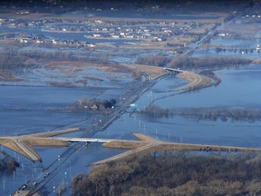 CORRECTS MONTH TO MARCH NOT MAY - The Elkhorn River consumes a section of western Douglas County Sunday, March 17, 2019, in Omaha, Neb. Hundreds of people were evacuated from their homes in Nebraska and Iowa as levees succumbed to the rush of water.