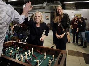 Democratic presidential candidate Sen. Kirsten Gillibrand, D-N.Y., high-fives a foosball opponent as partner Casey Leach of Manchester, N.H., laughs at a campaign meet-and-greet, Friday, March 15, 2019, at To Share Brewing in Manchester, N.H.