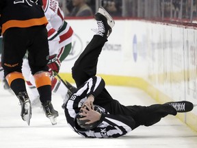 NHL linesman Ryan Daisy stumbles onto the ice during the first period of an NHL hockey game between the New Jersey Devils and the Philadelphia Flyers, Friday, March 1, 2019, in Newark, N.J.