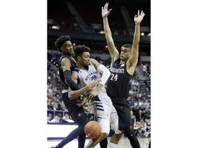 San Diego State's Jalen McDaniels, left, Nolan Narain, right, and Nevada's Jordan Brown get tangled up during the first half of an NCAA college basketball game in the Mountain West Conference men's tournament Friday, March 15, 2019, in Las Vegas.