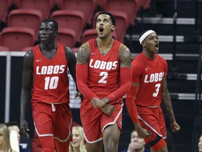 New Mexico's Caleb Martin, (10) Corey Henson (2) and Keith McGee (3) react after Henson scored during the first half of an NCAA college basketball game against Utah State in the Mountain West Conference men's tournament Thursday, March 14, 2019, in Las Vegas.