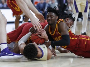 Washington's Matisse Thybulle, bottom left, and Southern California's Jonah Mathews fight for the ball during the first half of an NCAA college basketball game in the quarterfinal round of the Pac-12 men's tournament Thursday, March 14, 2019, in Las Vegas.
