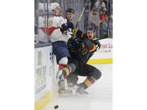 Vegas Golden Knights defenseman Jon Merrill (15) checks Florida Panthers center Jayce Hawryluk (8) into the boards during the first period of an NHL hockey game Thursday, Feb. 28, 2019, in Las Vegas.