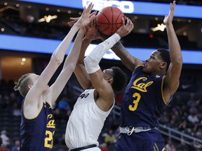 California's Connor Vanover, left, and Paris Austin guard Colorado's Tyler Bey during the first half of an NCAA college basketball game in the first round of the Pac-12 men's tournament Wednesday, March 13, 2019, in Las Vegas.