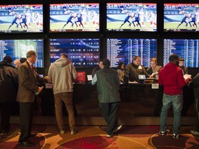 FILE - In this Thursday, Dec. 13, 2018, file photo, gamblers place bets in the temporary sports betting area at the SugarHouse Casino in Philadelphia. About six in 10 Americans want betting on professional sports events to be legal in their state, but fewer feel that way about college athletics, according to a new poll conducted by The Associated Press-NORC Center for Public Affairs Research released Wednesday, March 20, 2019.  The poll finds 42 percent favor legal betting on college sports.