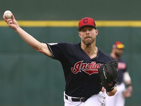 FILE - In this March 11, 2019, file photo, Cleveland Indians starting pitcher Corey Kluber throws a warm up pitch before a spring training baseball game against the Cincinnati Reds in Goodyear, Ariz.  The Indians have their sights set on their first World Series title since 1948, but to get it they'll have to replenish some power lost during the offseason and get by league powers Houston, New York and Boston.