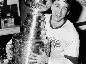FILE - In this April 16, 1954, file photo, Detroit Red Wings captain Ted Lindsay hugs the Stanley Cup after his team defeated the Montreal Canadiens, 4-3, in a sudden death extra period to win the Stanley Cup finals, in Detroit. Detroit Red Wings great and Hall of Famer Ted Lindsay died Monday, March 4, 2019, at his home in Michigan. He was 93. His death was confirmed Monday by son-in-law Lew LaPaugh, president of the Ted Lindsay Foundation, which raises money for autism research.(AP Photo/File)