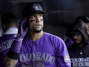 FILE - In this June 18, 2018, file photoColorado Rockies' Carlos Gonzalez walks in the dugout after scoring against the New York Mets during the second inning of a baseball game in Denver. A person familiar with the agreement says Gonzalez intends to sign a minor league contract with the Cleveland Indians. Gonzalez, who played the past 10 seasons with Colorado, will sign once he completes a physical and join the Indians at spring training, said the person who spoke Saturday, March 16, to The Associated Press on condition of anonymity because the deal has not been finalized.