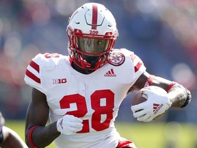 FILE - In this Oct. 13, 2018, file photo, Nebraska's Maurice Washington runs during the second half of an NCAA college football gam against Northwestern, in Evanston, Ill. Washington is in line to be the Cornhuskers' starting running back in the fall. A California judge signed an arrest warrant for Washington three weeks ago on charges related to his possession and distribution of a video of his former girlfriend being sexually assaulted by two other people in 2016.